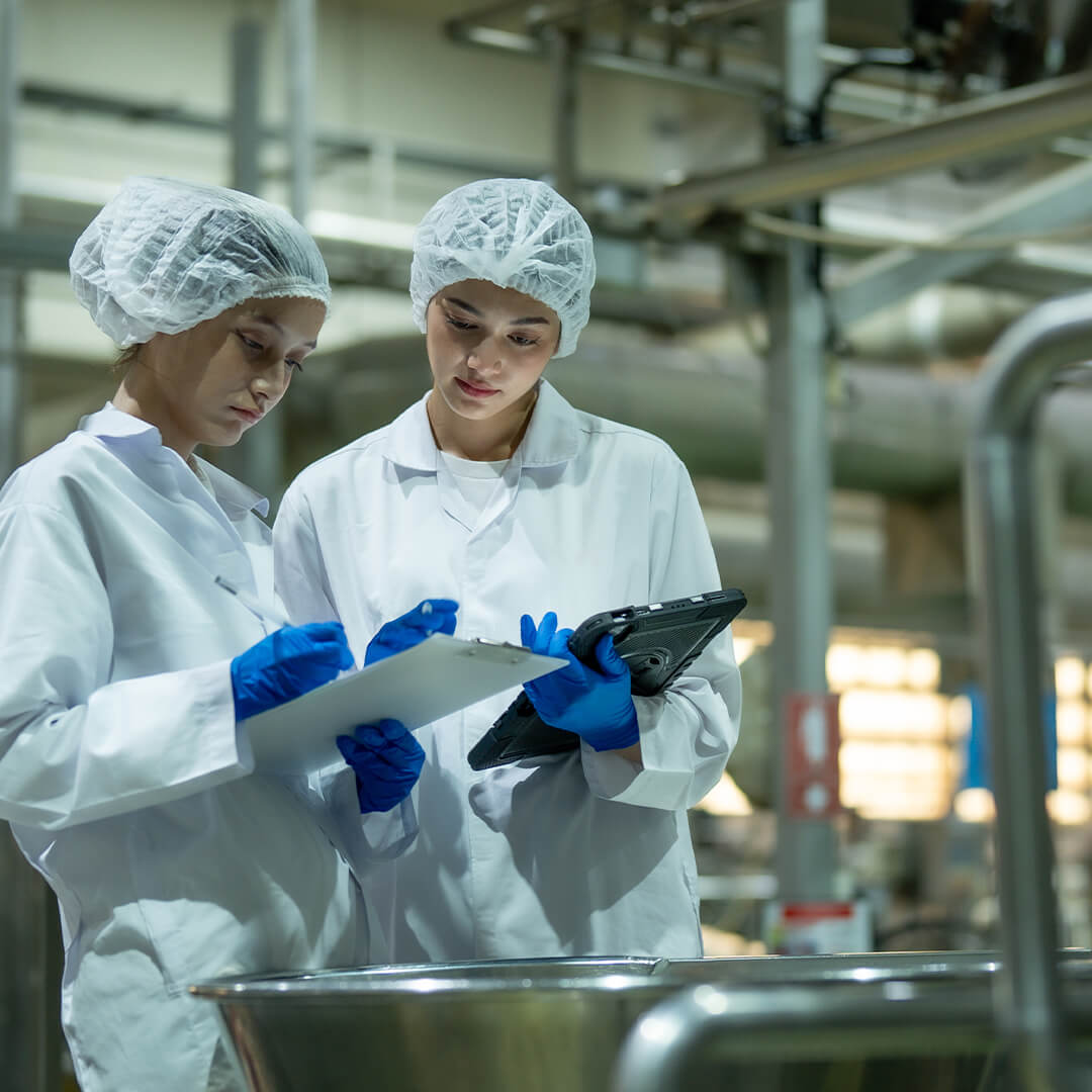 Zwei Mitarbeiterinnen prüfen mit Tablet und Klemmbrett eine Charge in der NutraPet-Produktion in Schlaitdorf